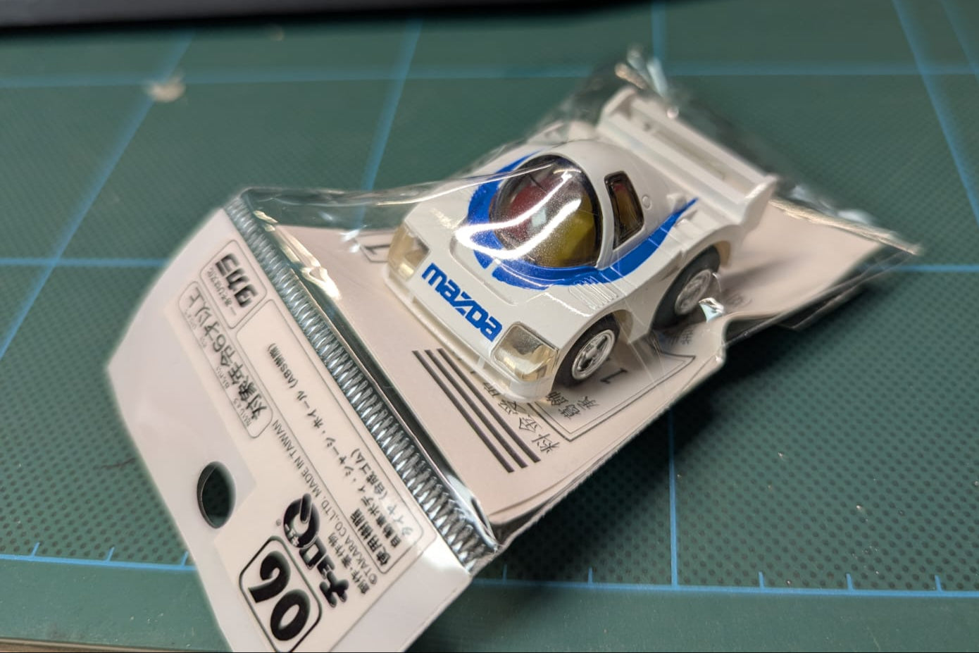 Model car in packaging on a cutting mat