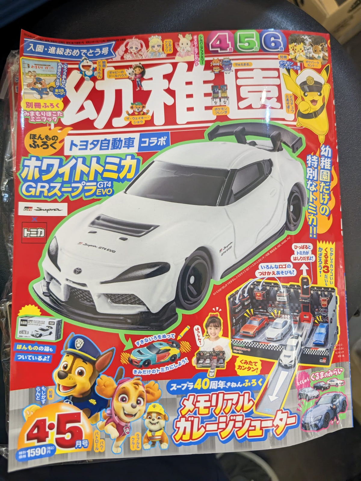 Shogakukan Kindergarten April May 2024 magazine featuring White Tomica Toyota GR Supra GT4 EVO and Memorial Garage Shooter